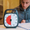 Time Timer Plus med kille i bakgrunden som gör läxor